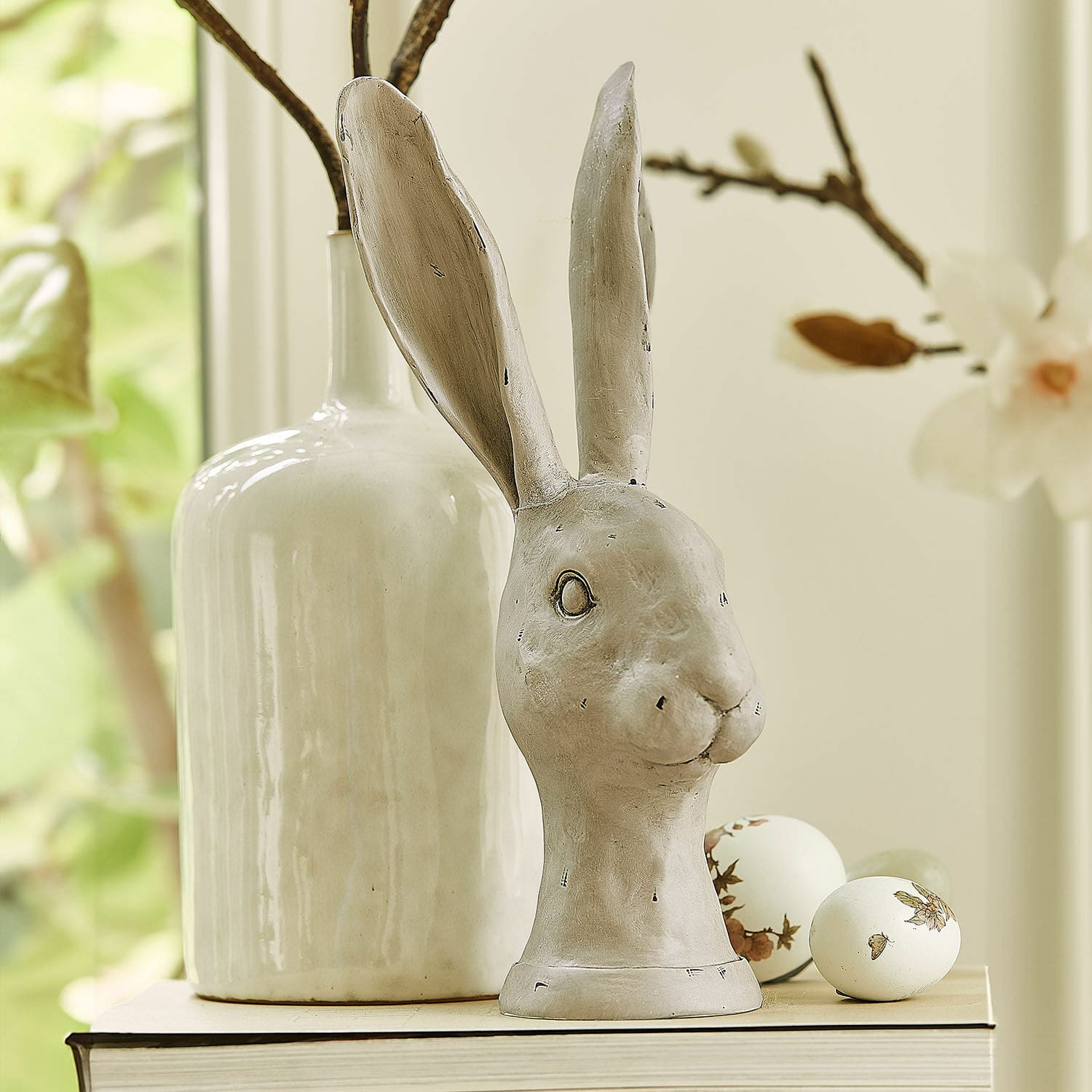 Lapin Najirah Figurine décorative de lapin en céramique grise posée sur un livre avec des œufs décoratifs