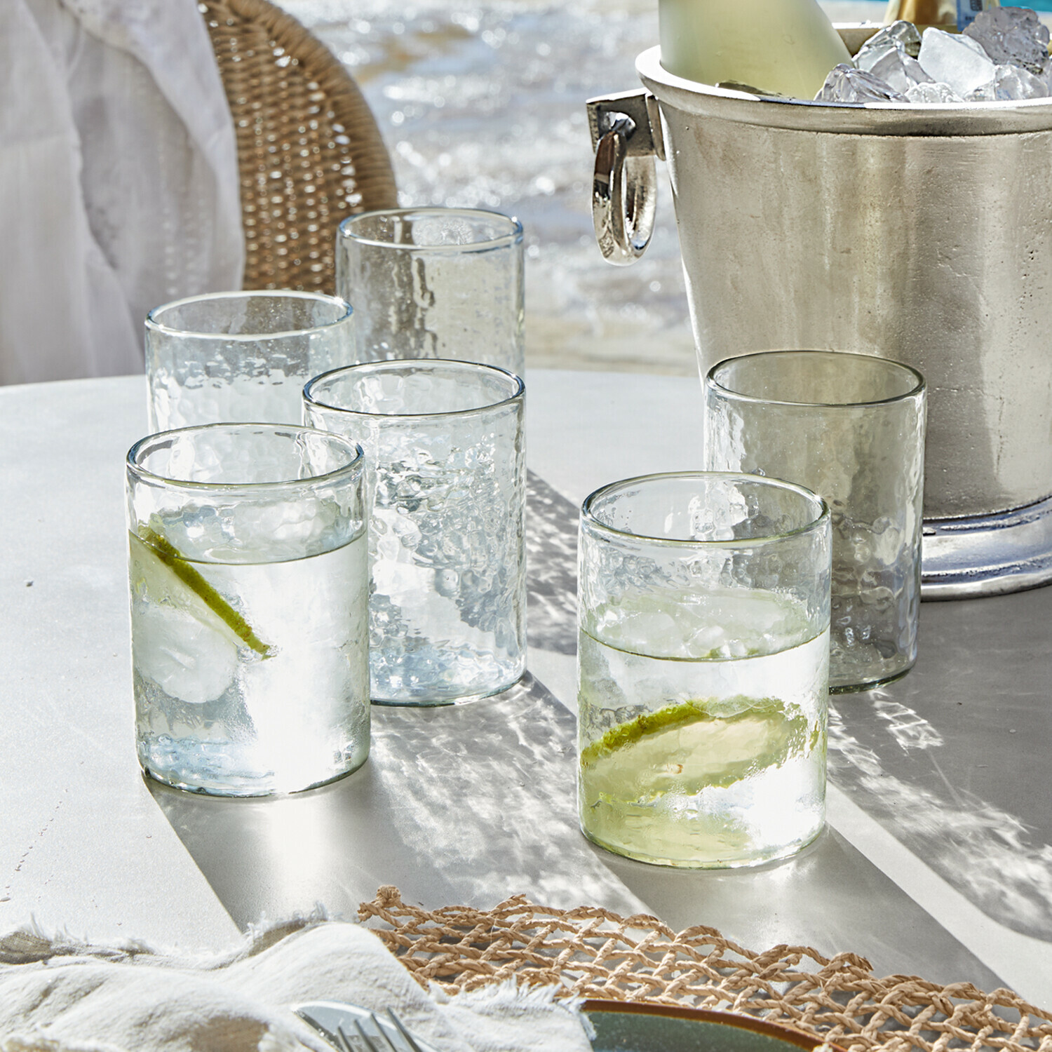 Lot de 6 verres Clarksville Verres en verre transparent texturé avec tranches de citron vert et glaçons sur table blanche
