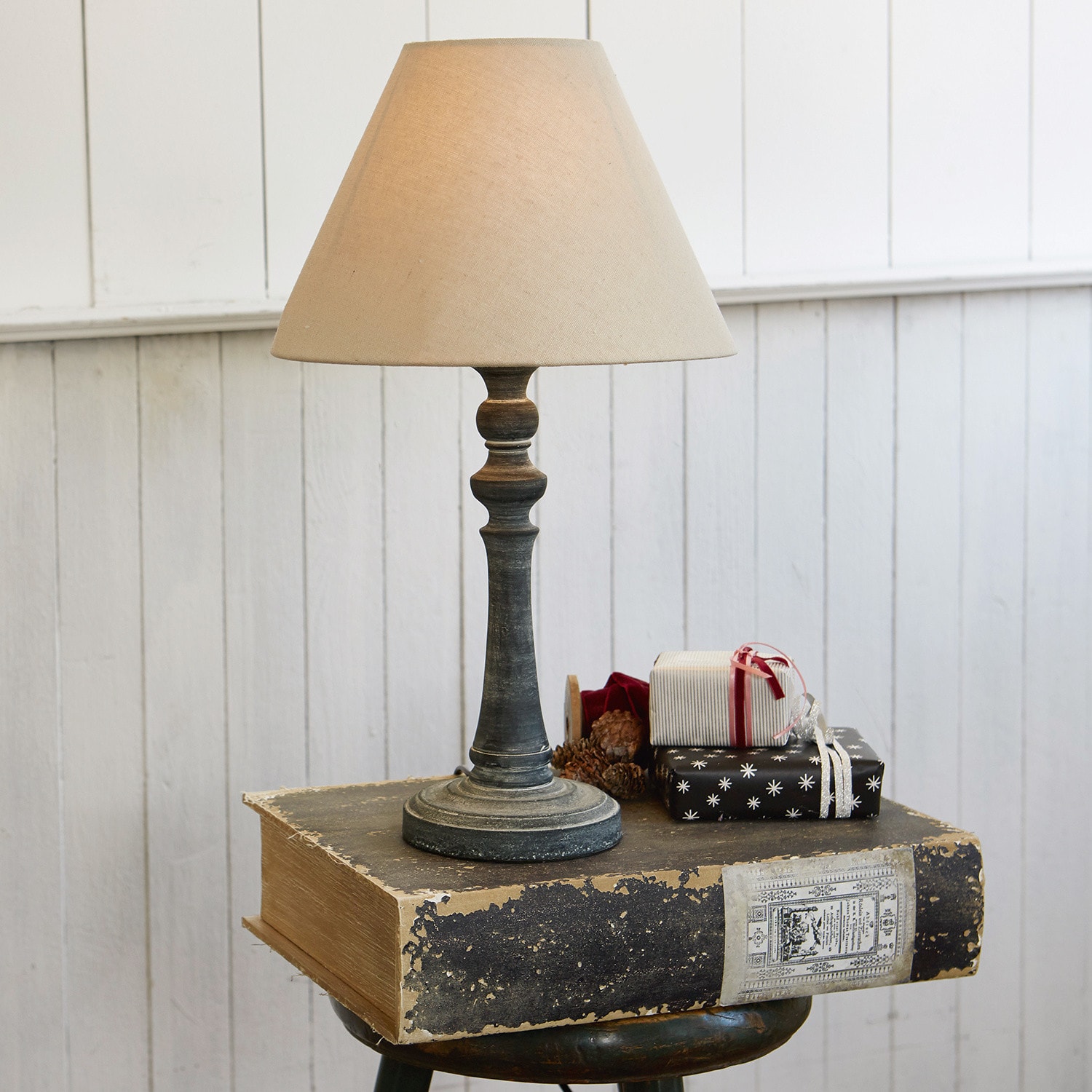 Lampe à poser Withby Lampe de table avec abat-jour beige et pied noir vieilli sur fond de mur blanc