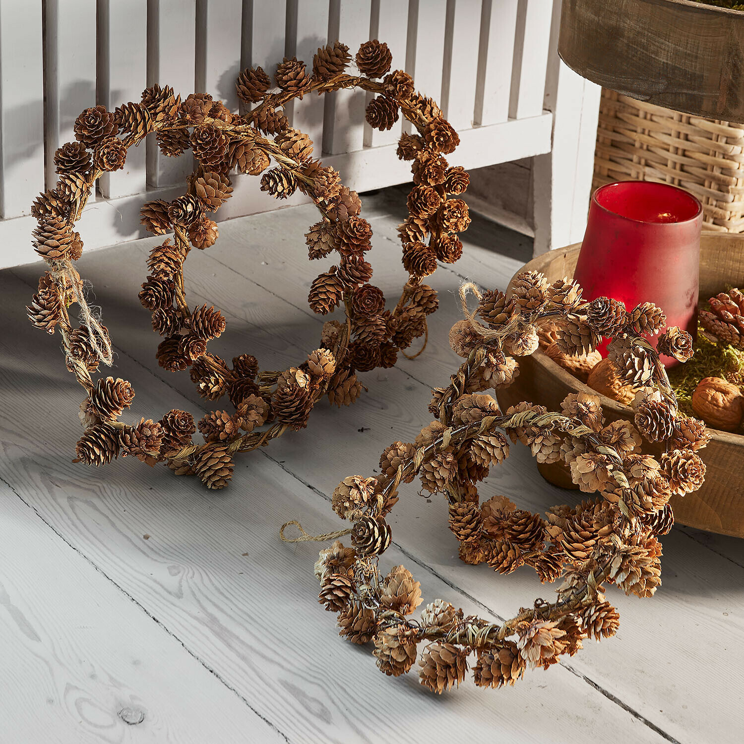 Couronne set de 4 Alberinan Couronnes décoratives naturelles en pommes de pin marron posées sur un sol en bois clair