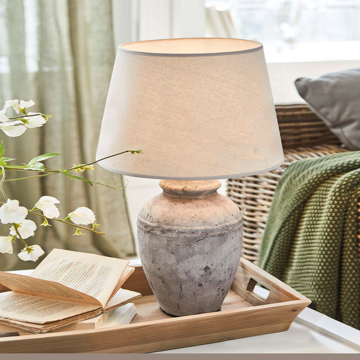 Lampe à poser Mosnay Lampe de table en céramique grise avec abat-jour beige posée sur un plateau en bois