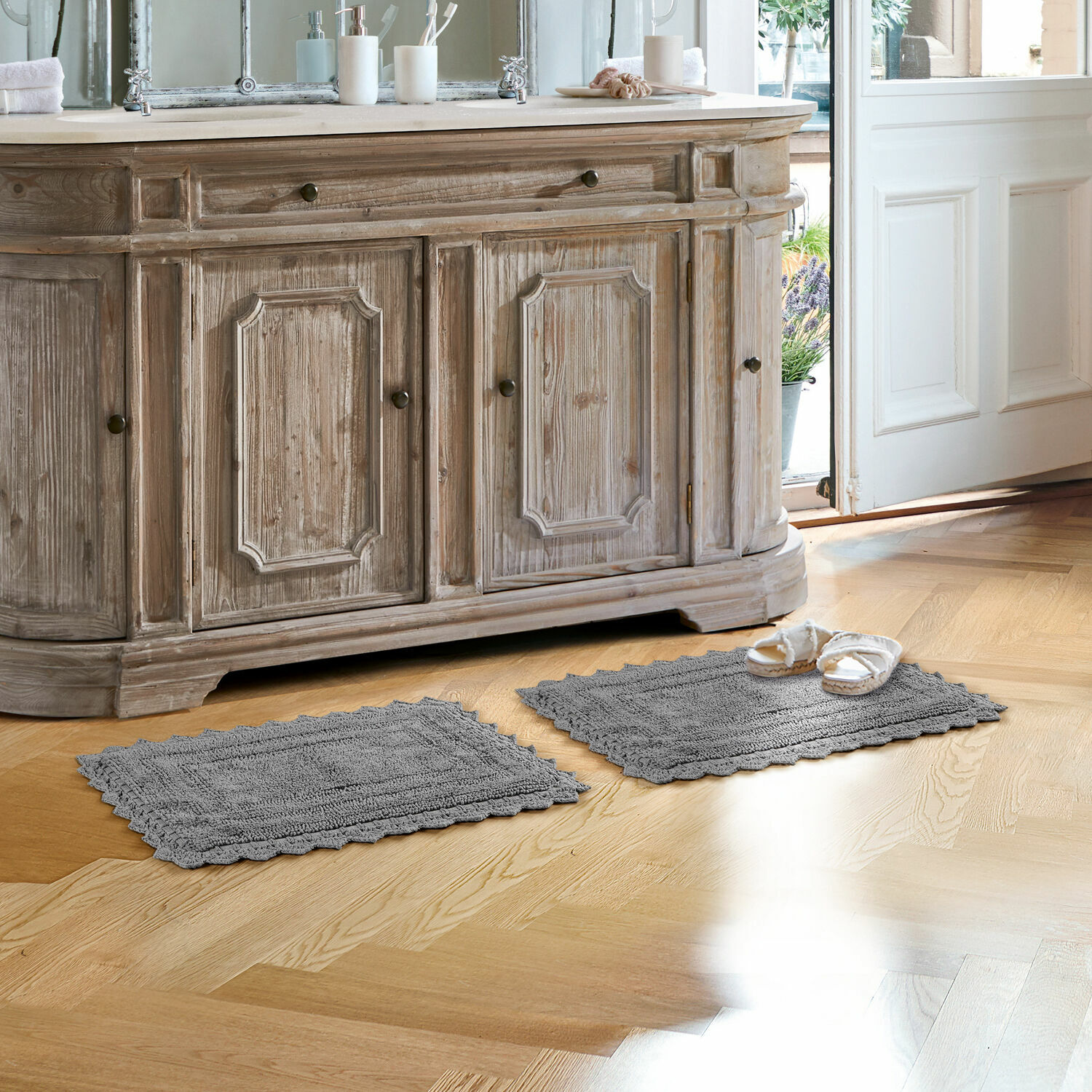 Tapis de bain Yalexir Tapis de bain gris en coton sur parquet clair devant un meuble rustique en bois avec lavabo