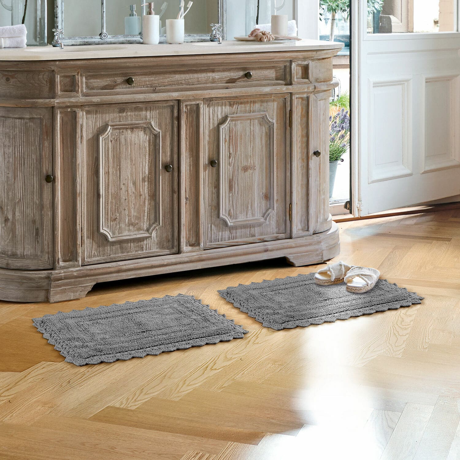 Tapis de bain Yalexir Tapis de bain gris en coton sur parquet clair devant un meuble rustique en bois avec lavabo