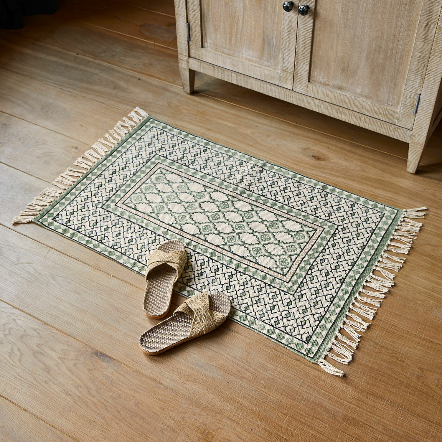 Tapis de bain Vellantino Tapis en coton vert et crème avec franges sur sol en bois, décoration intérieure élégante