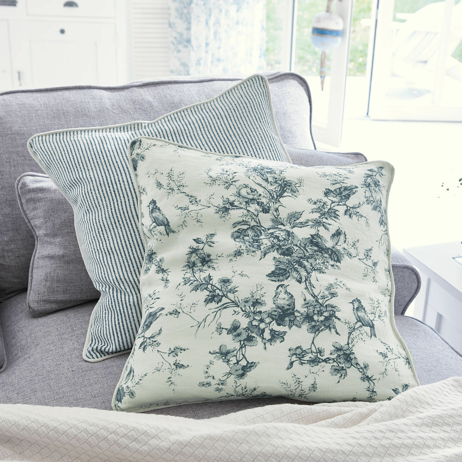 Lot de 2 coussins Emilie Coussin décoratif réversible en coton avec motifs floraux et rayures bleues sur canapé gris