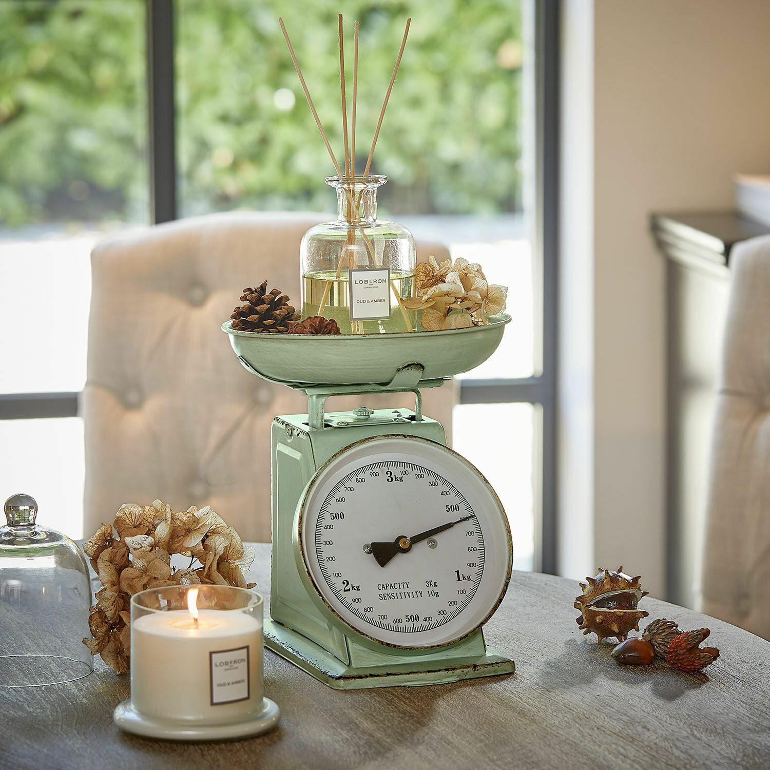 Balance de cuisine Dorianza Balance de cuisine en métal vert menthe avec diffuseur parfumé et bougie sur table en bois