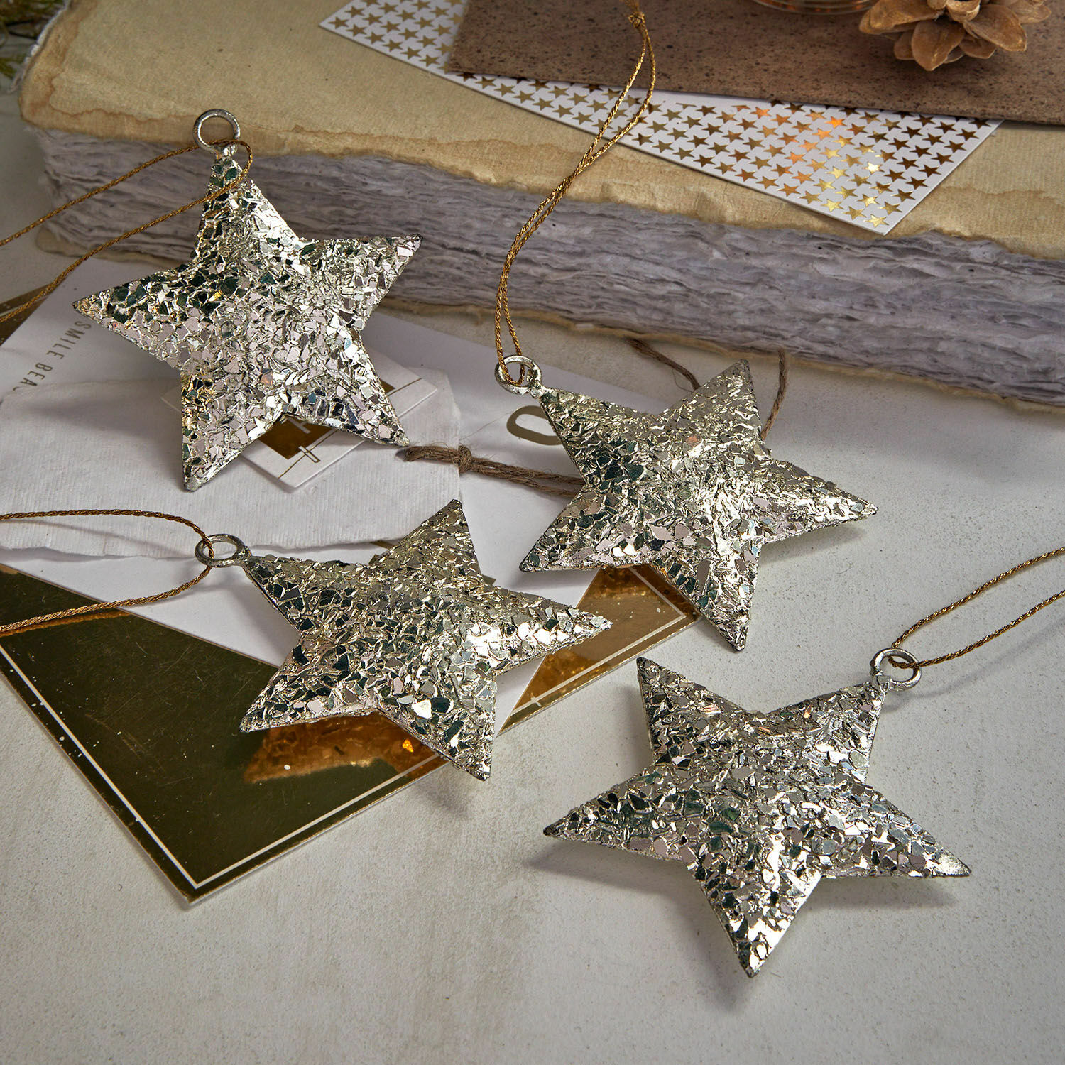 Lot de 4 décorations à suspendre Veyari Ensemble de quatre étoiles argentées texturées à suspendre, décoration de Noël brillante