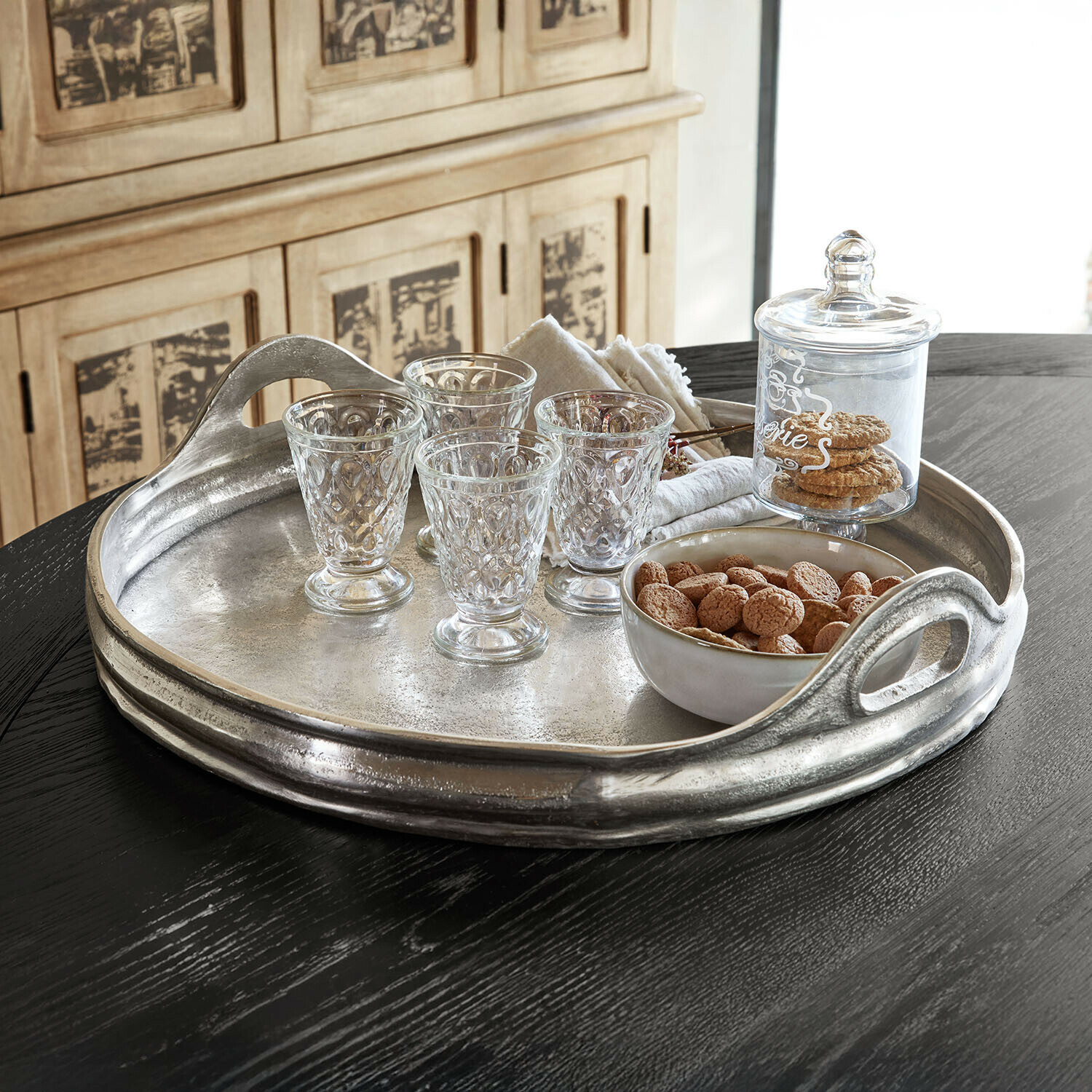 Plateau Téloriane Plateau en métal avec poignées, verres en verre et bol de biscuits sur table noire pour service élégant