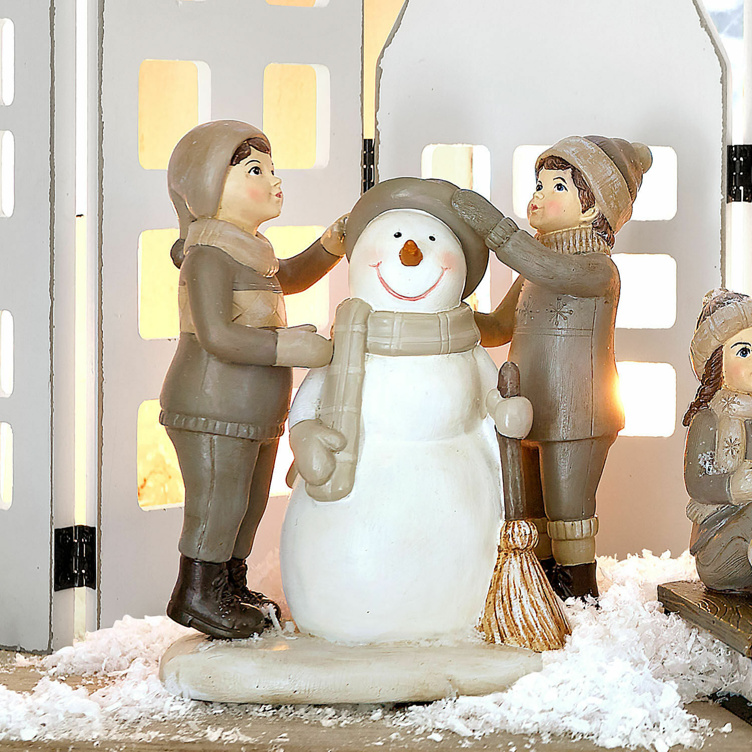 Figurine décorative Elvirette Figurines d'enfants habillant un bonhomme de neige en matériaux beige et marron sur neige décorative