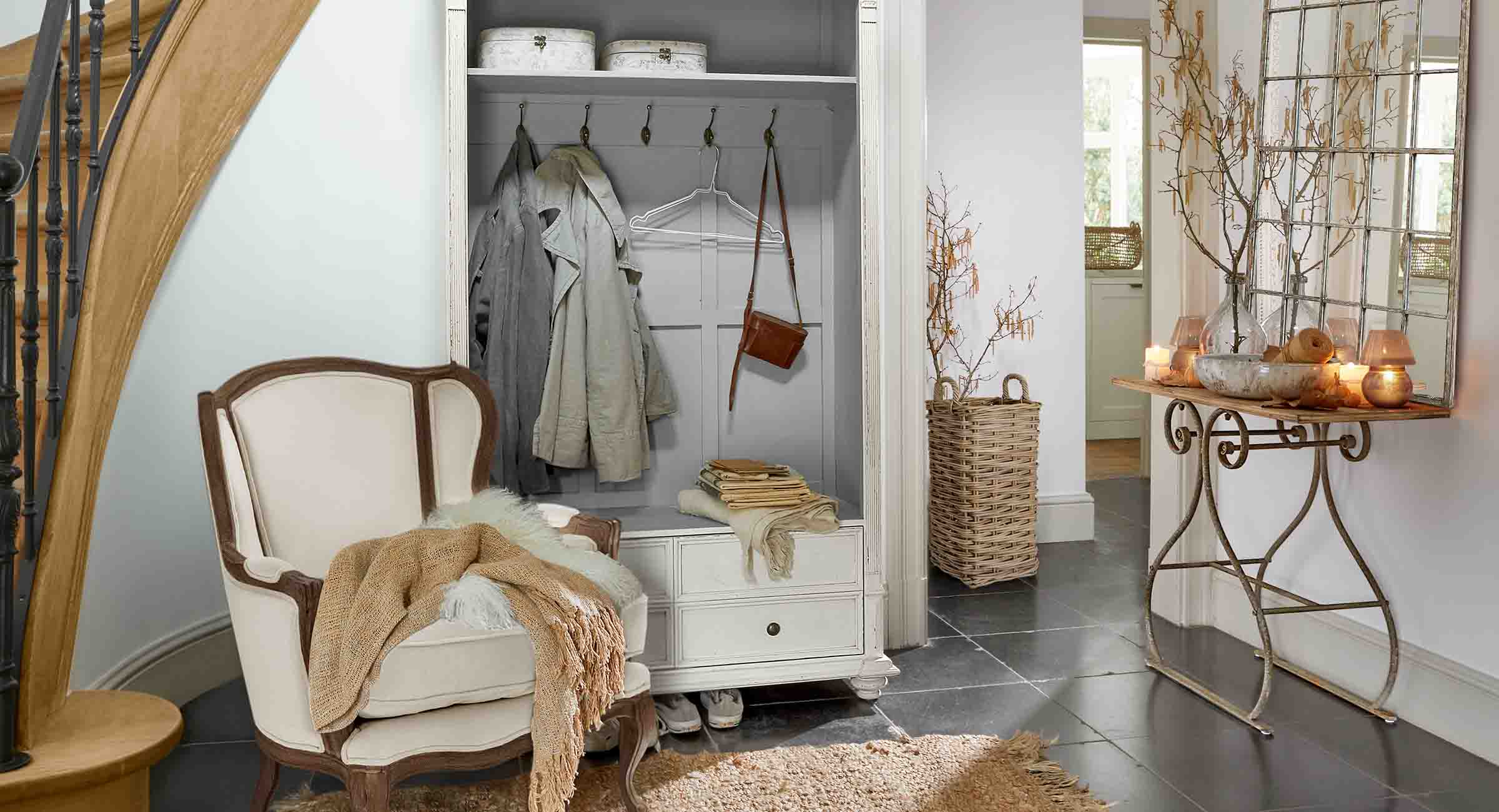 Coin accueillant avec fauteuil blanc, armoire à vêtements et miroir avec console en métal style vintage